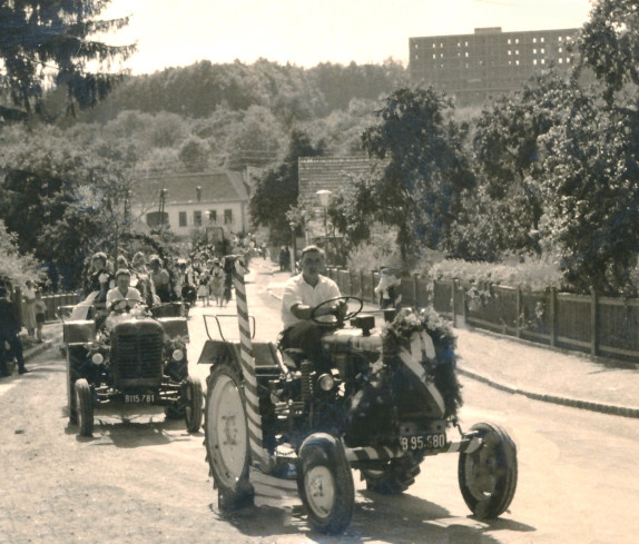 Festzug entlang der Hauptstraße mit dem im Bau befindlichen Hauptgebäude der PVA